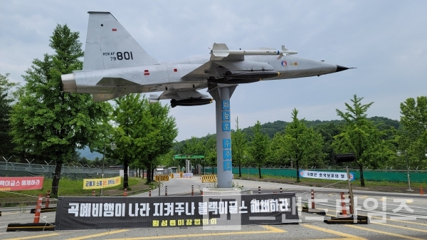 블랙이글스를 해체하라는 현수막이 제8전투비행단 입구 조형물 아래 설치되어 있다/사진=브랜드타임즈