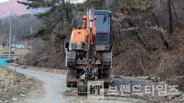 여름 장마로 토사가 쌓인 개울을 정비하고 트럭으로 올라가는 포크레인/사진=브랜드타임즈